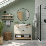 Bathroom walls painted a soft sage green with a wood vanity below a round mirror.