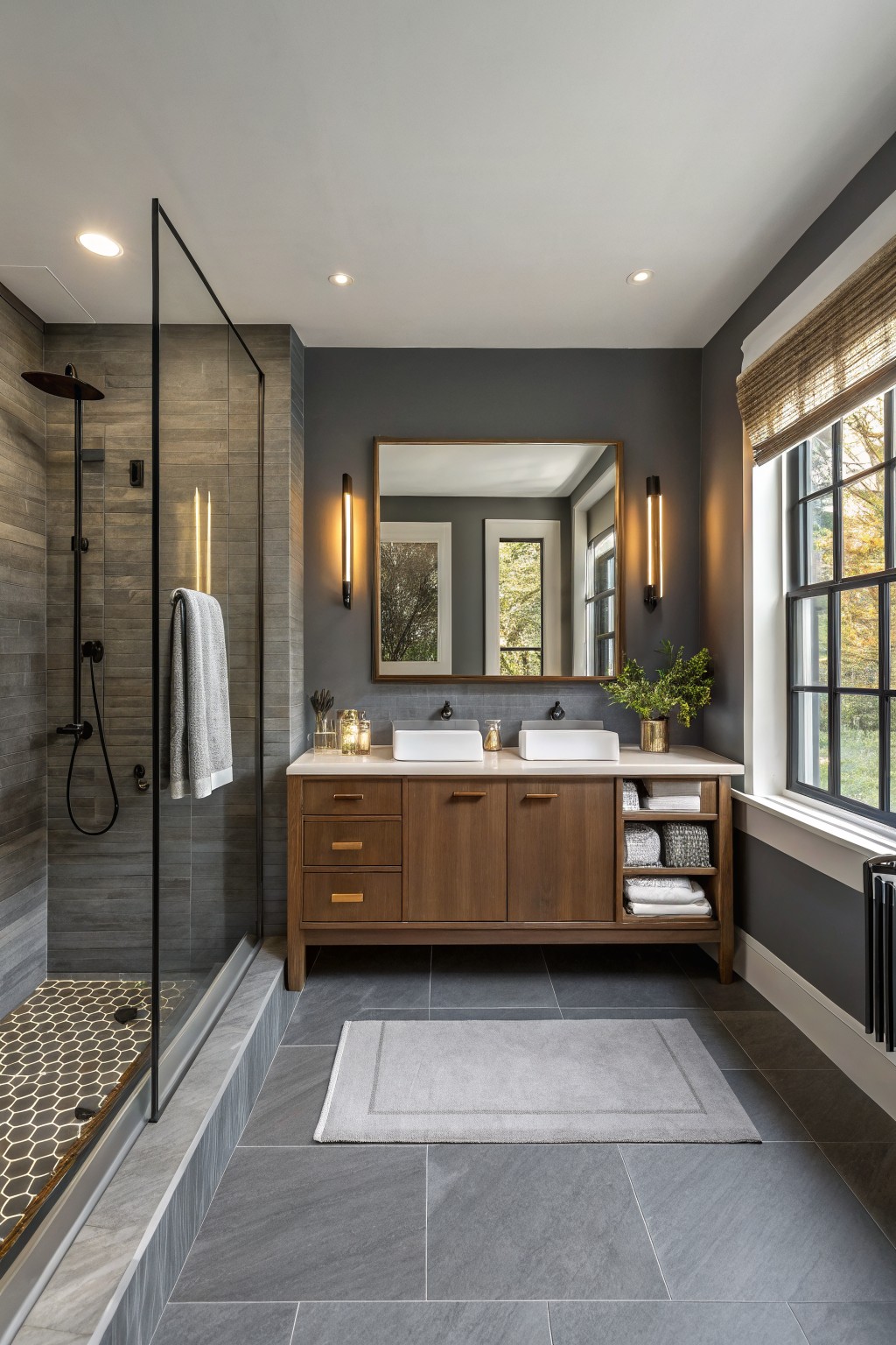 Bathroom walls painted in a soft charcoal gray with a wood vanity and white sinks.