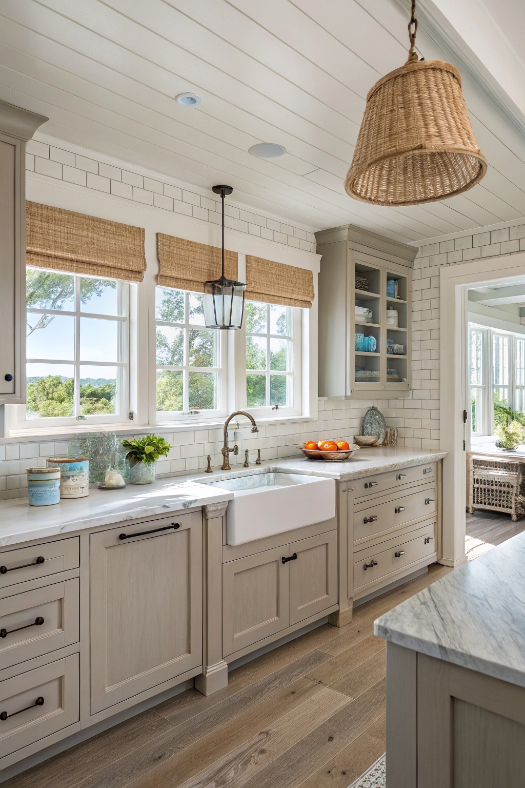 Light taupe kitchen cabinets with white countertops and windows above the sink.
