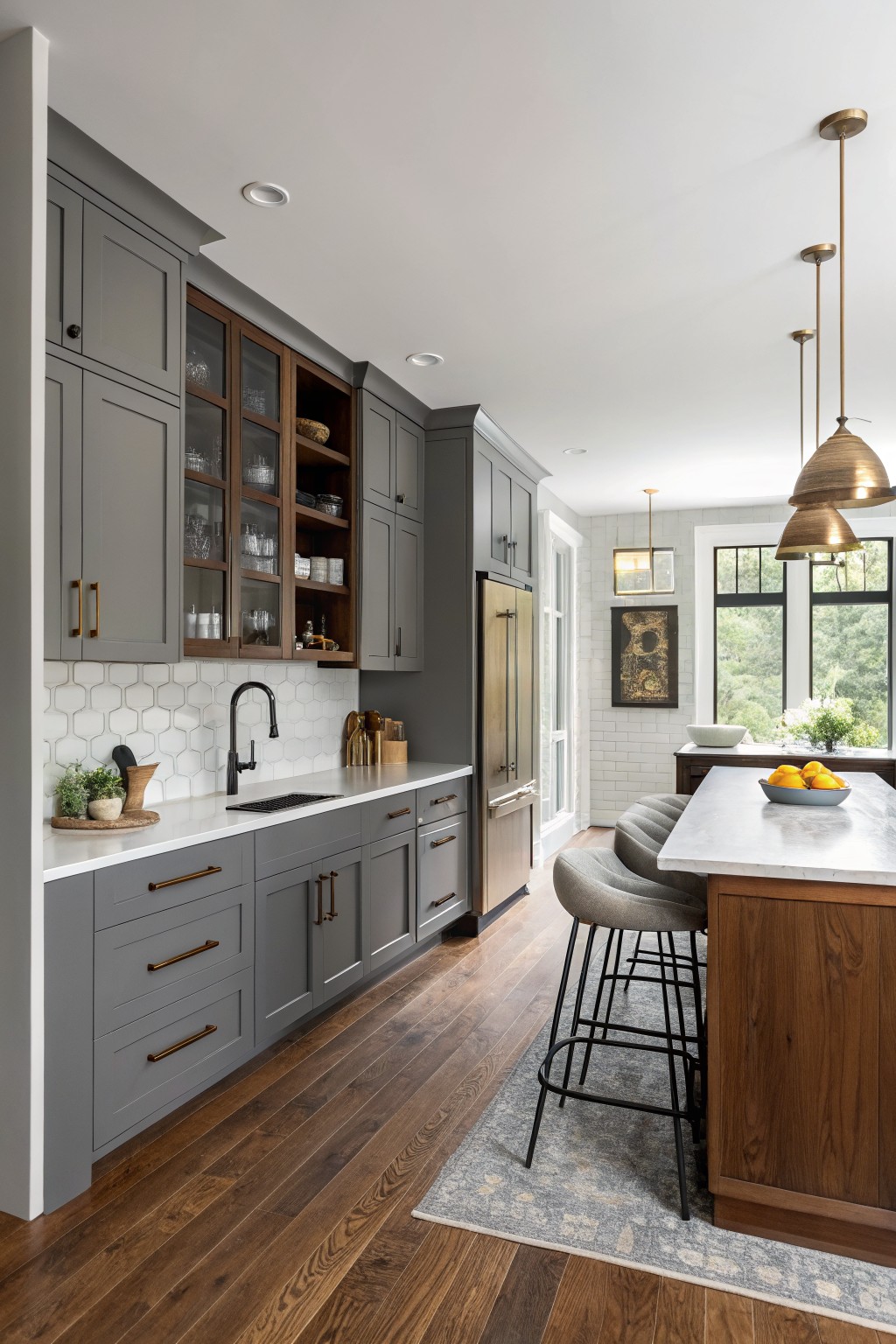 Gray kitchen cabinets with wood accents and a white countertop.
