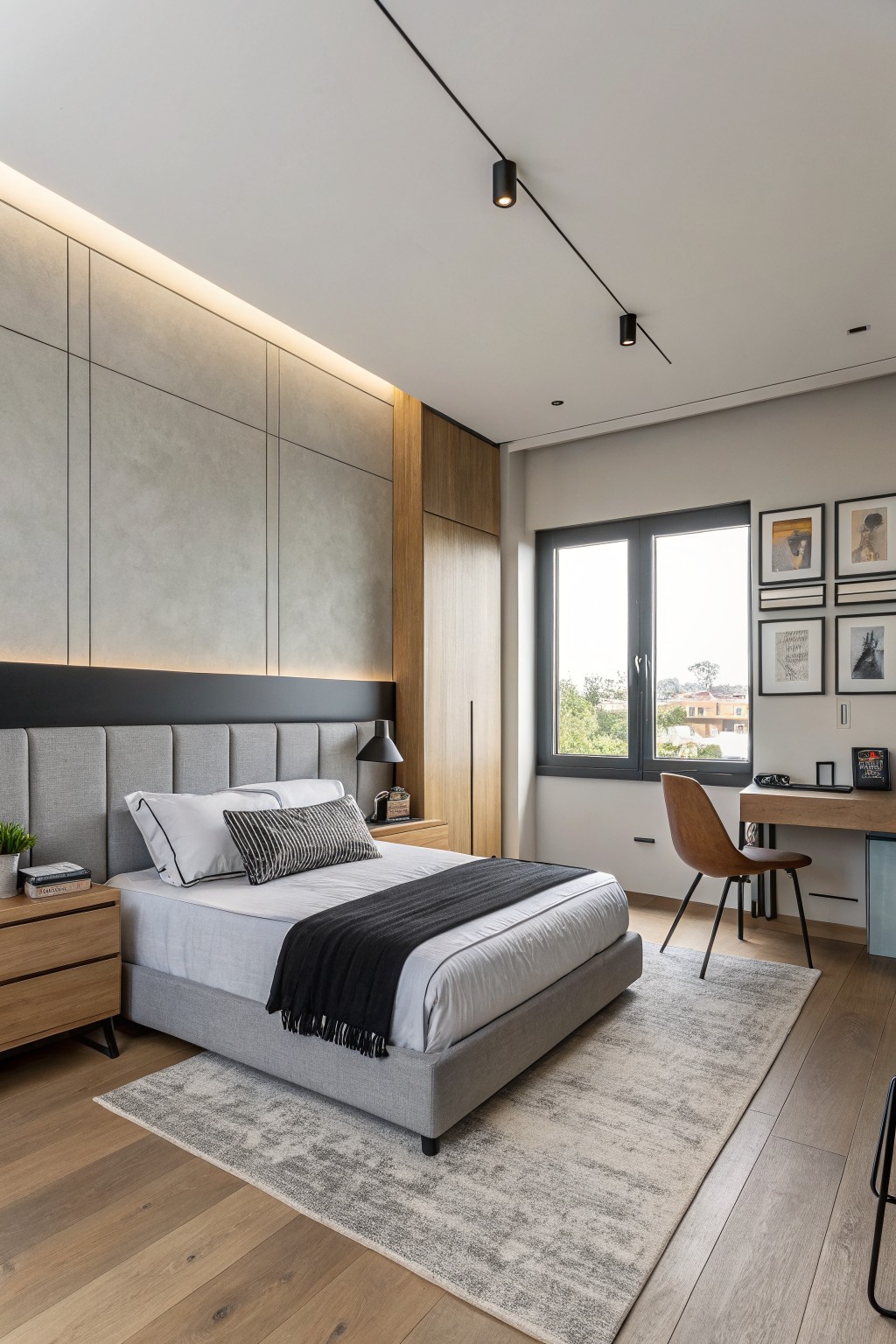 A bedroom featuring soft greige walls behind a gray upholstered bed.
