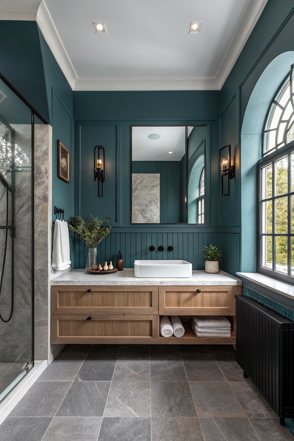 A bathroom with deep teal walls and a wooden vanity.
