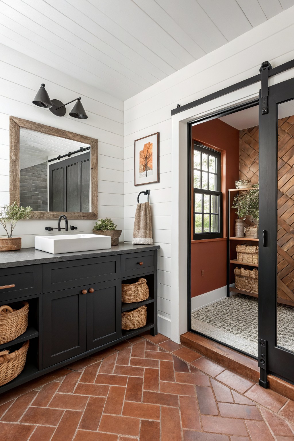 Black painted vanity and sliding door in a bathroom with white walls and terracotta tile.