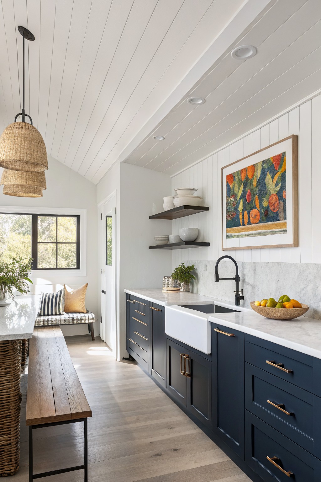 Dark navy blue kitchen cabinets with white walls and marble backsplash.