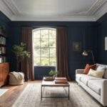 A living room with deep navy blue walls and a gray sofa.