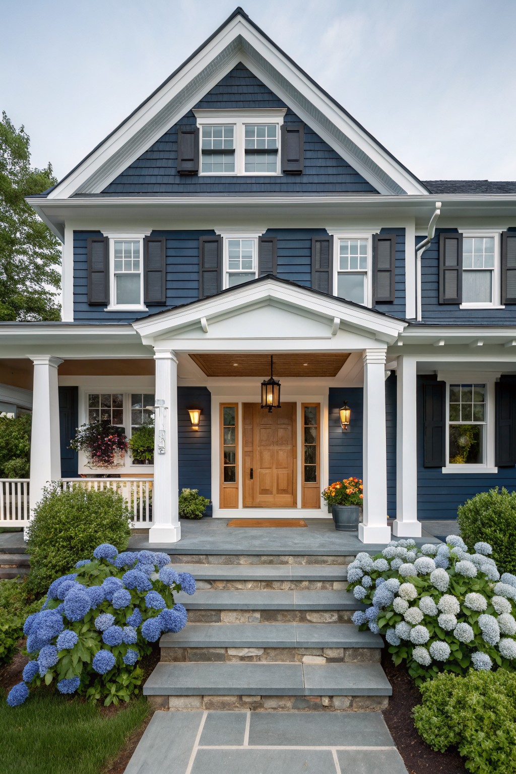 A two-story house with dark navy blue siding and white trim on the front porch.