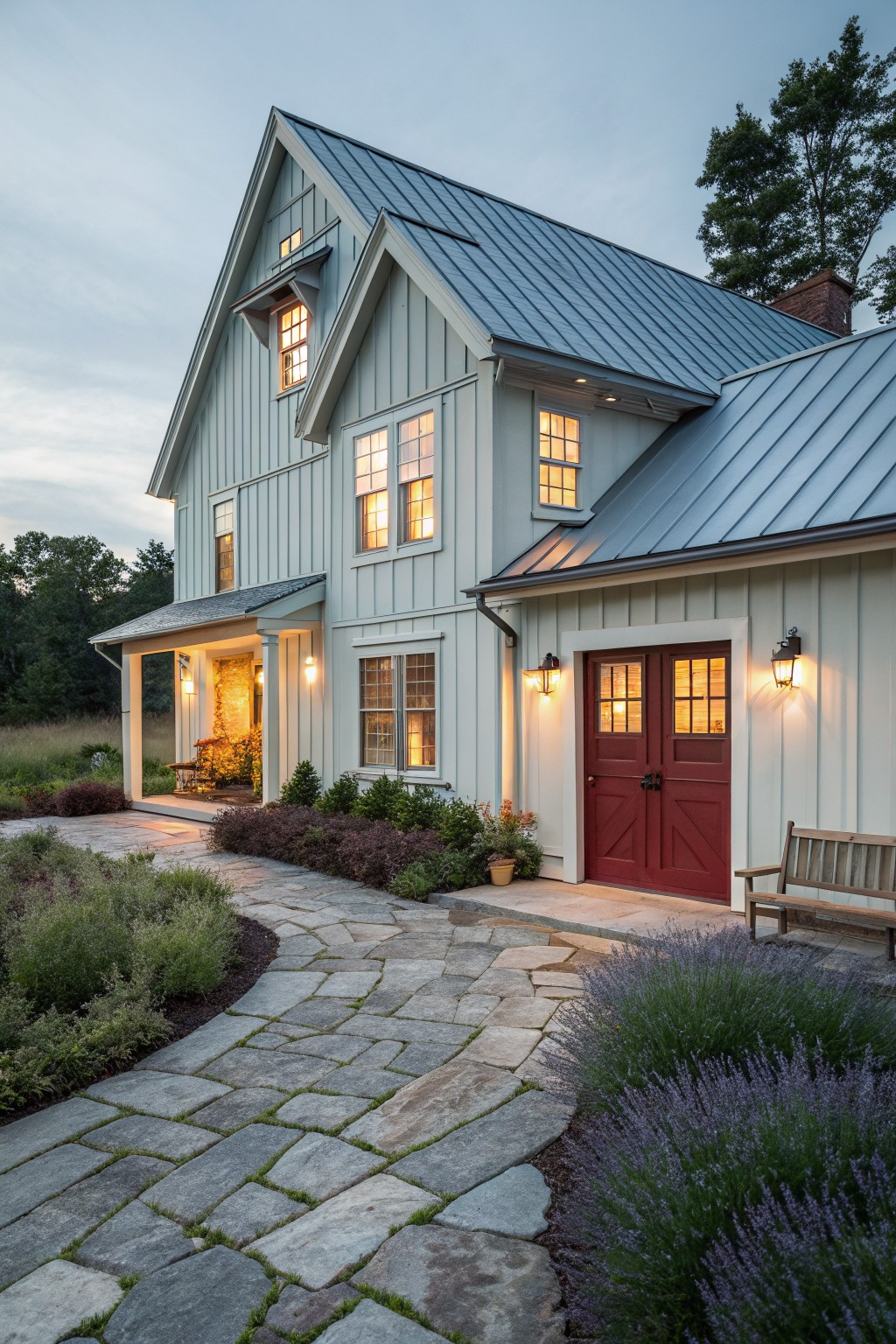 Light green house with red doors, glowing windows, and stone path at dusk