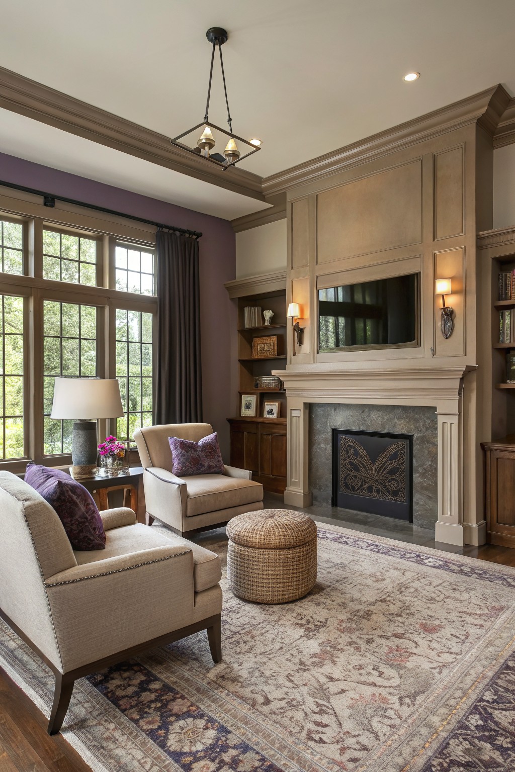 Warm greige walls surround a stone fireplace in a living room with built-in cabinetry.