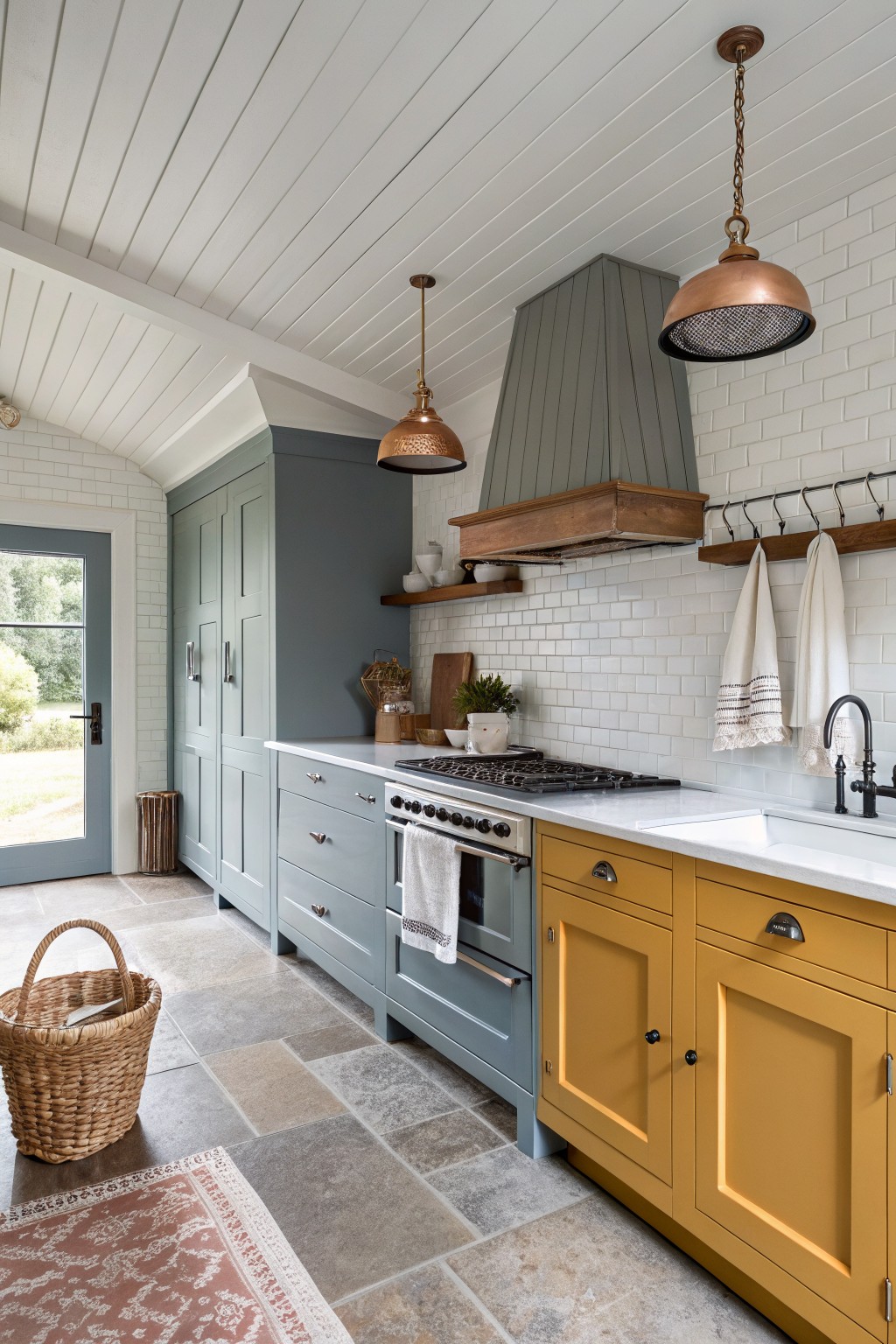 Two-tone kitchen cabinets painted sage green and golden yellow with white countertops.