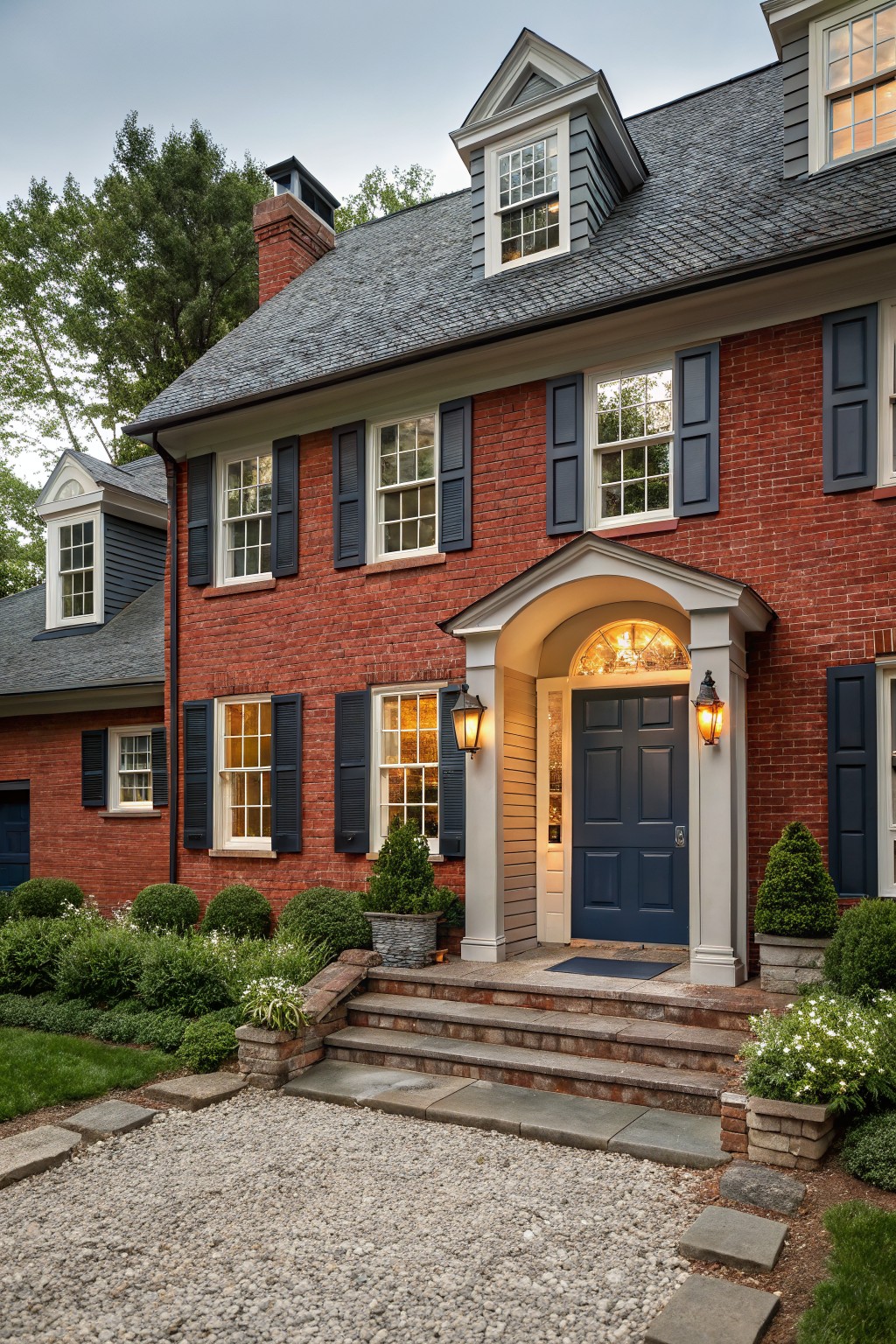 A red brick house with a deep navy blue front door and matching shutters.