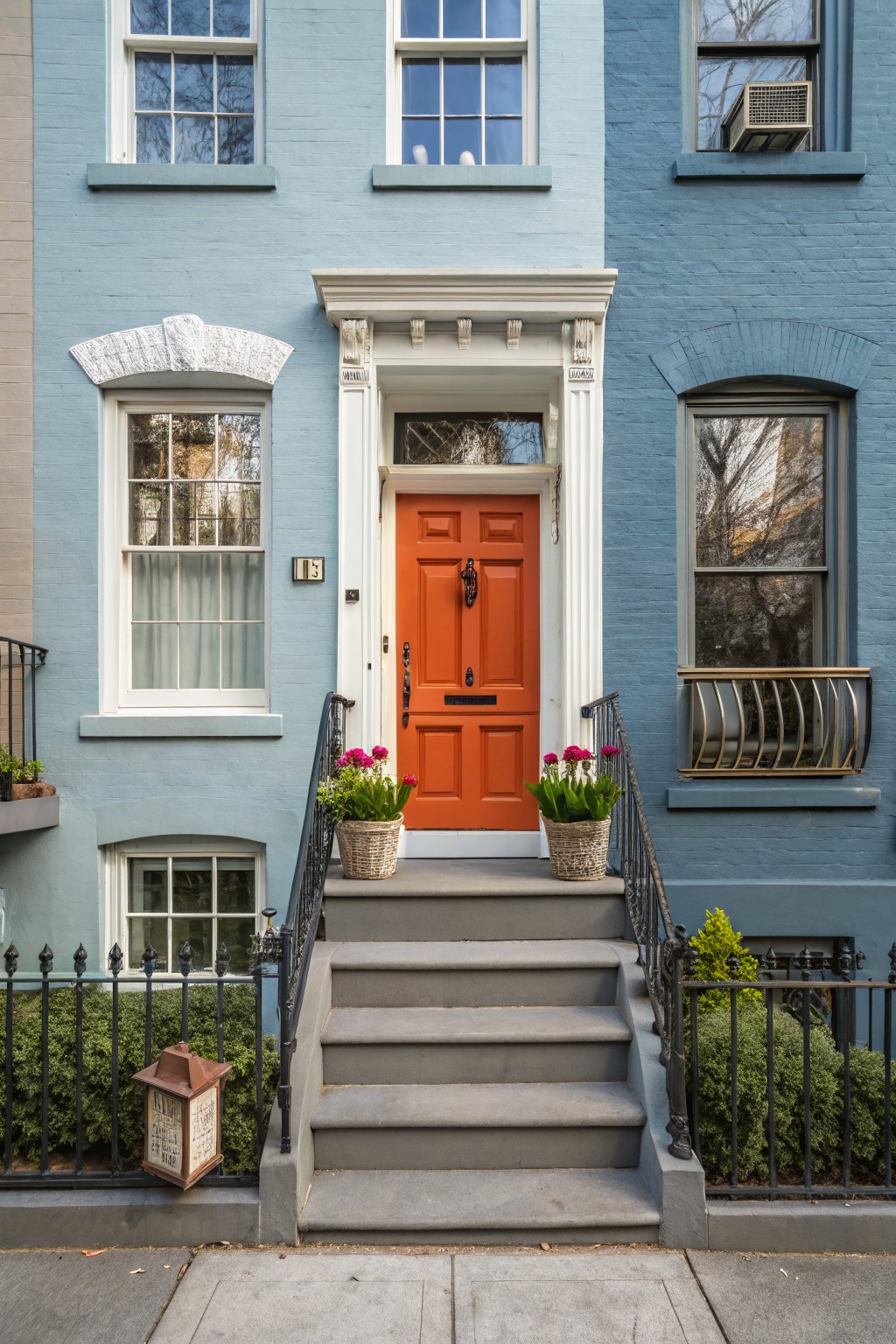 A house with light blue gray siding and white trim around the windows and door.