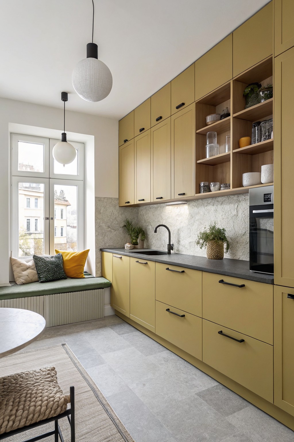 Warm olive green kitchen cabinets with open shelving and dark countertops.