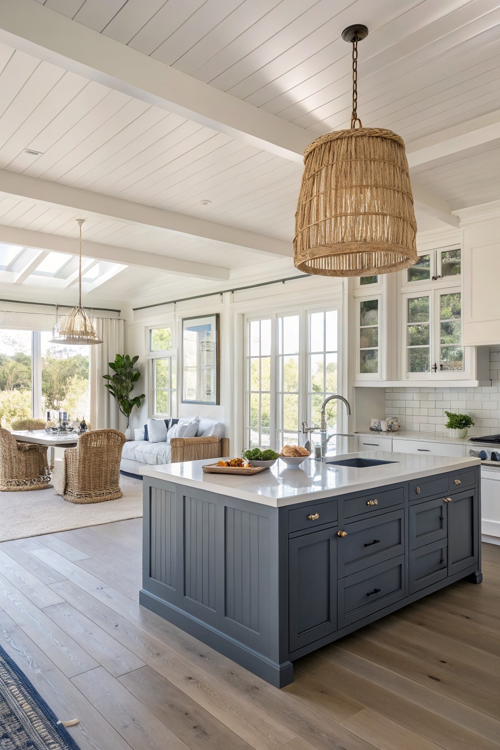 A kitchen island painted in a deep blue gray with white countertops.