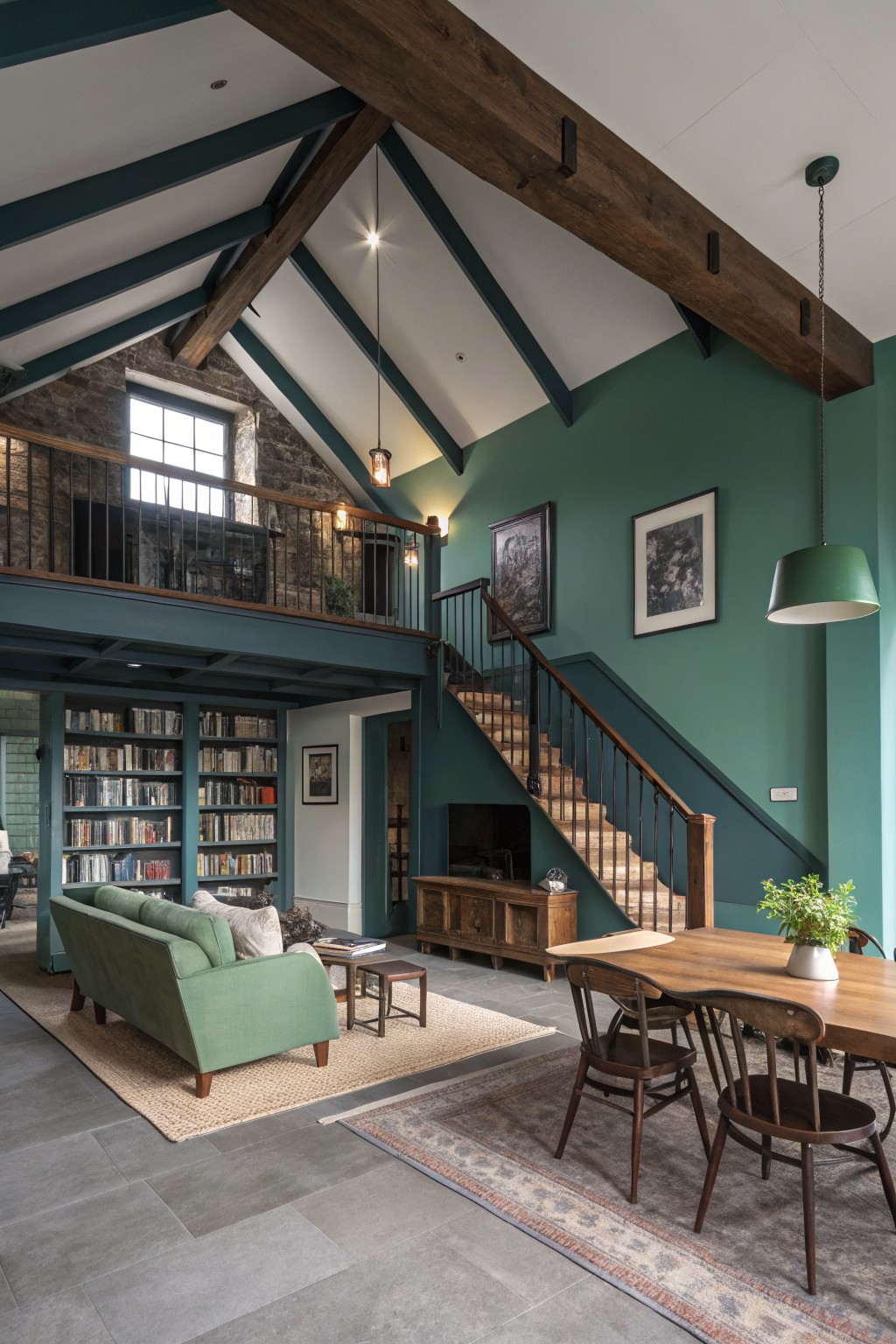 Deep teal green walls in a tall open living room with wood beams and a staircase.