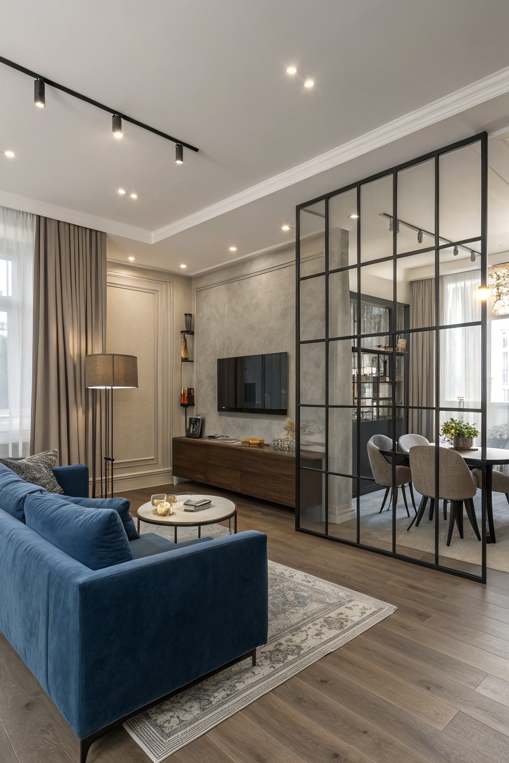 Light greige walls in an open living room with wood floors and a glass partition.