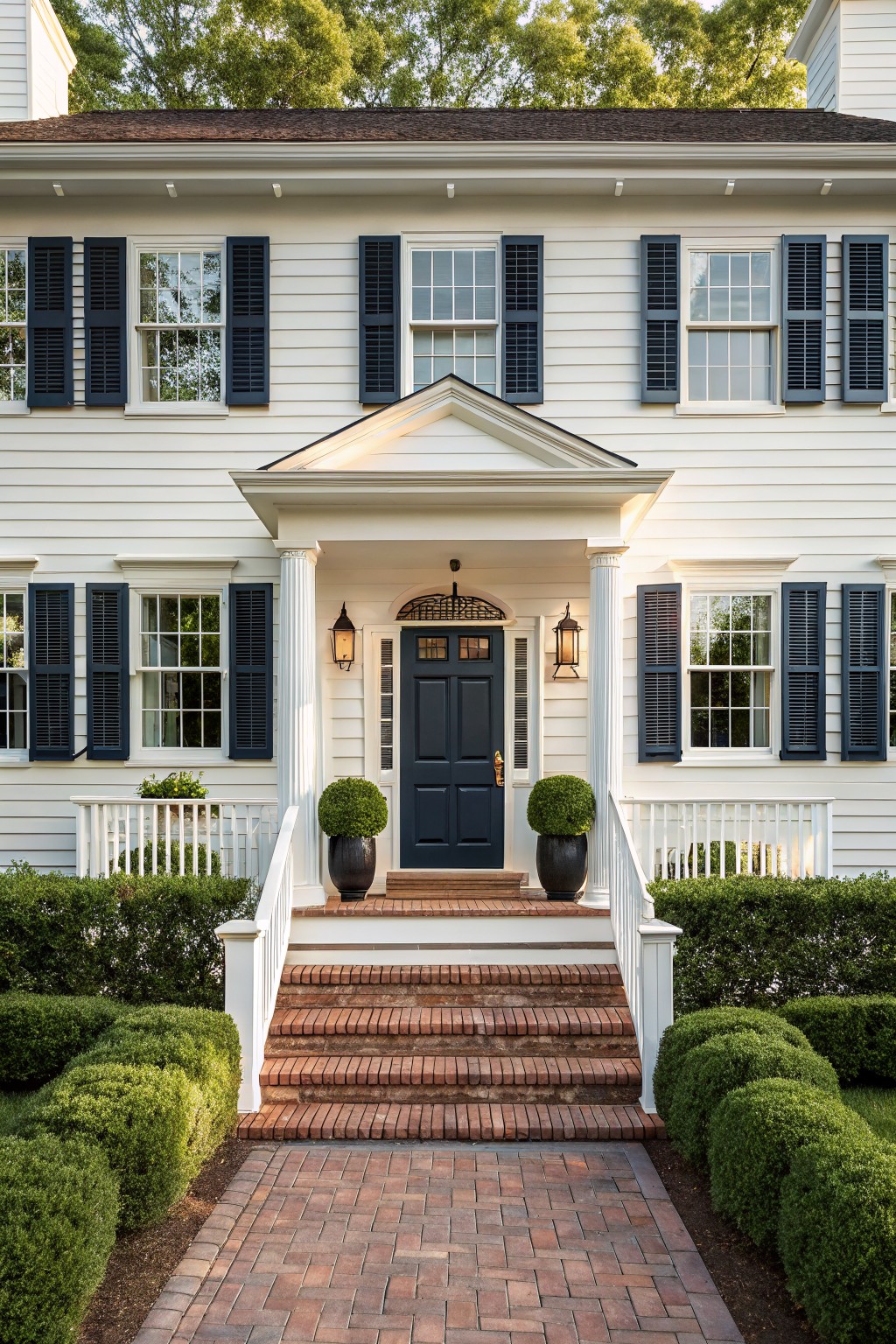 A white house exterior with a dark navy front door and brick steps.
