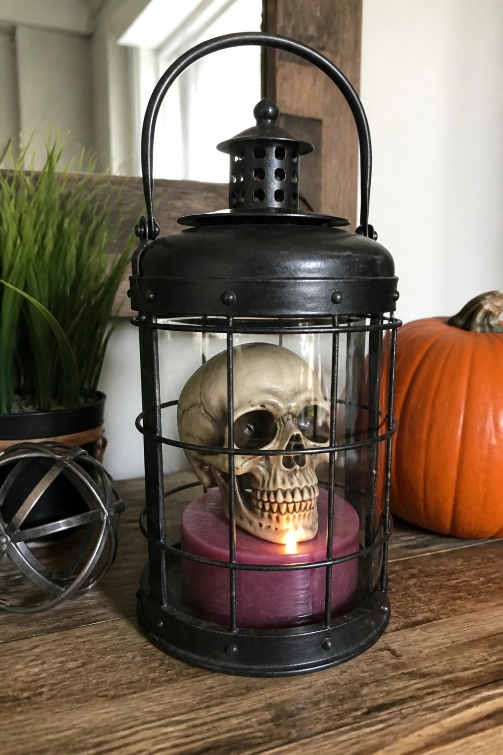 Black metal lantern holding a skull on top of a lit purple candle.